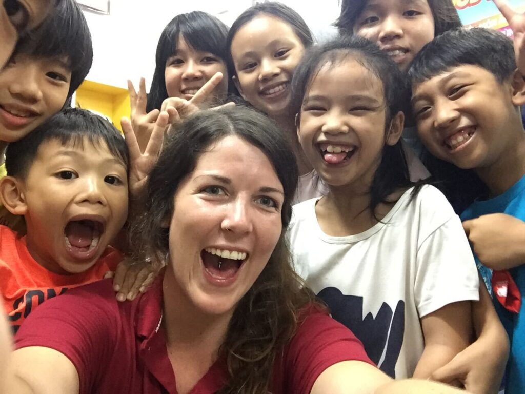 Kendra and a few of her former students smiling at the camera